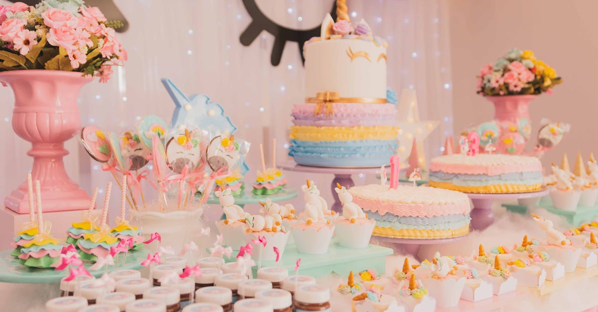 A vibrant unicorn-themed birthday party setup with cakes, cupcakes, and decorations.