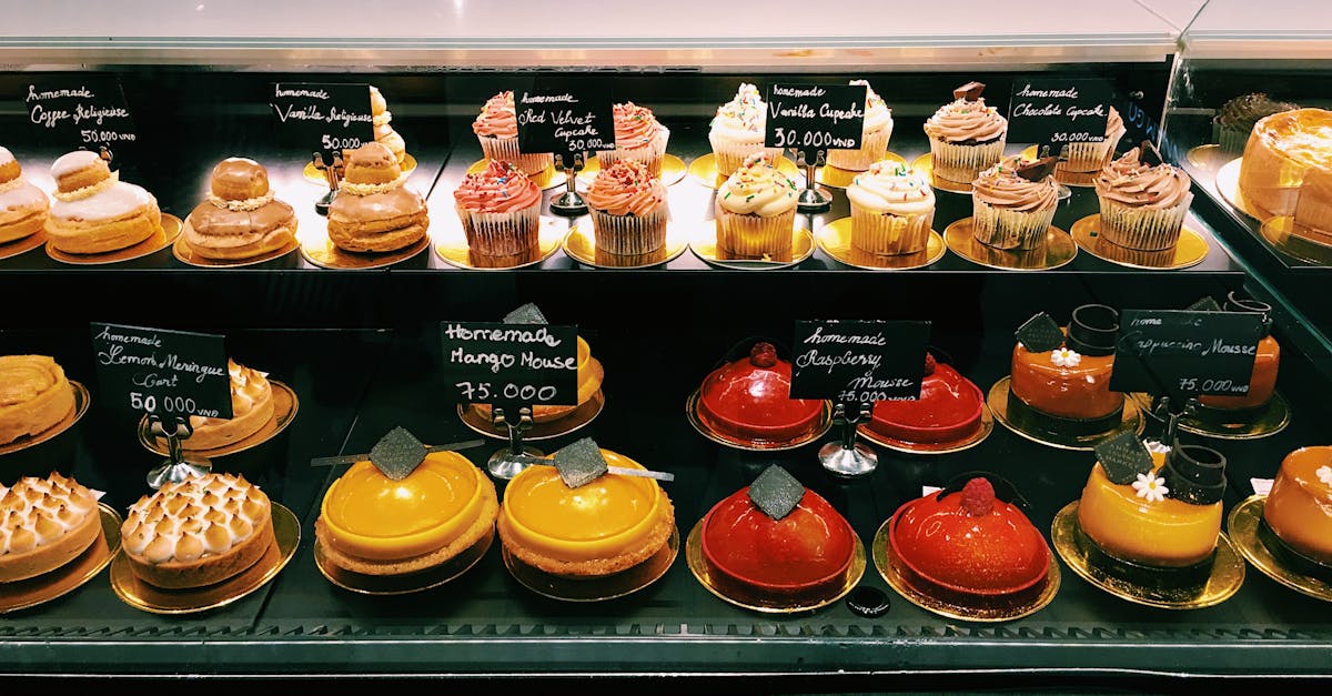 An enticing display of homemade cupcakes and pastries in a bakery showcase, perfect for dessert enthusiasts.