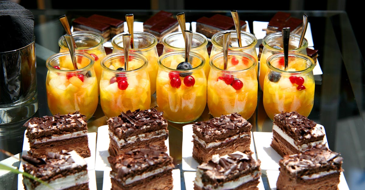 Enticing dessert table featuring fruit salad jars and chocolate cakes, perfect for celebrations.